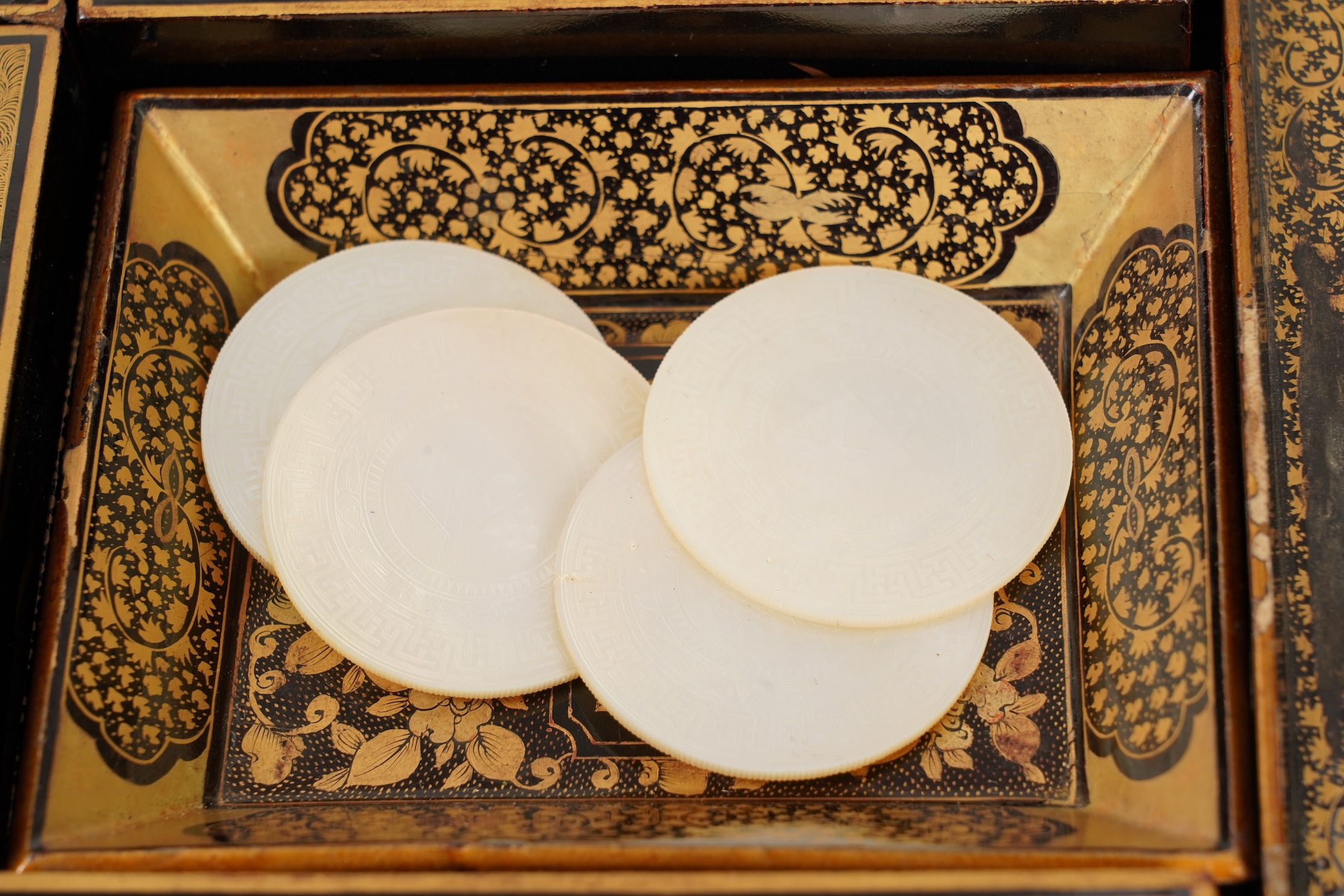 Two Chinese gilt decorated black lacquer games boxes, containing numerous mother-of-pearl counters, 19th century